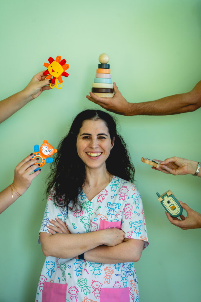 A fisioterapeuta Luísa realiza uma sessão de osteopatia pediátrica, interagindo de forma delicada com um bebé deitado na marquesa
